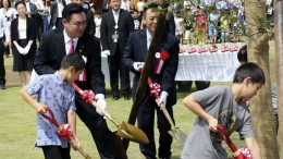 Мэр города Нараха Юки Мацумото сажает дерево с детьми