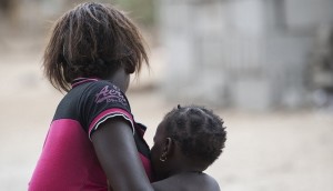 17-летняя мама сидит с ребенком в в южной части Мозамбика